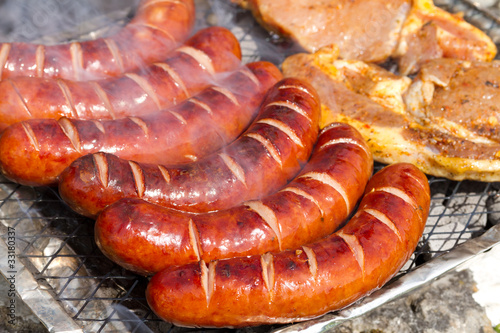 Photo: Grilled sausages and pork on the barbecue Grilled sausages and pork on the barbecue