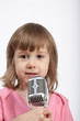 Closeup little girl in pink with microphone.