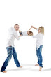 Father and mother in white shirts and jeans swing child
