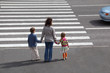mother holds hand of daughter and son and is going on road