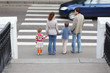 mother and father holds hand of children and standing in city