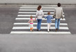 mother and father holds hand of children and crossing road