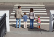 parents holds hand of daughter and son and standing on crossing
