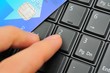 Photo: Finger and credit card on keypad Finger and credit card on keypad