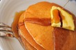 Pouring maple syrup on pancakes