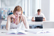 Photo: in the library - pretty female student with laptop and books wor in the library - pretty female student with laptop and books wor