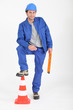 Builder with foot on traffic cone.