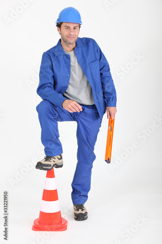 Photo: Builder with foot on traffic cone. Builder with foot on traffic cone.