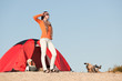 Camping happy woman outside tent on beach