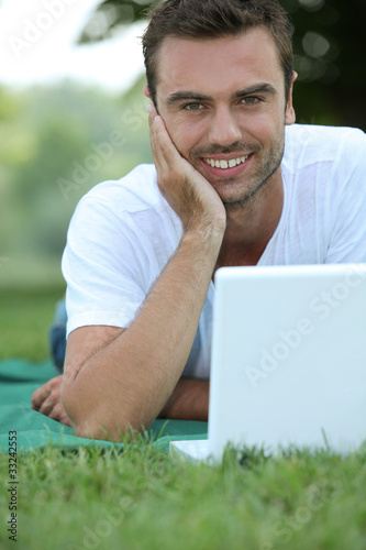 Photo: Man on laptop outside Man on laptop outside