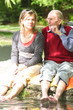 Großvater und Enkelin beim Entspannen im Grünen am Teich