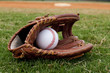 Baseball in Old Glove on Field