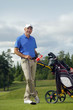 Man standing by golf bag full of sticks Man standing by golf bag full of sticks