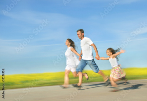 Foto: Happy family running on meadow Happy family running on meadow