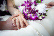 Hands and rings on wedding bouquet