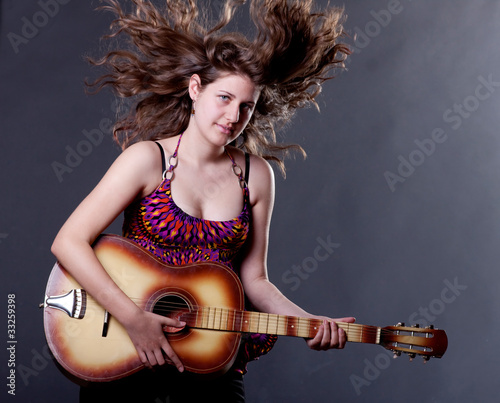 Photo: Young woman playing guitar Young woman playing guitar