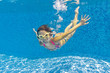 Photo: Happy smiling underwater kid in swimming pool Happy smiling underwater kid in swimming pool