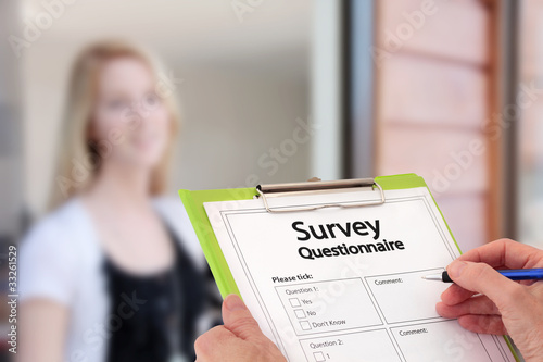 Photo: Girl Answering Market Research Survey Questionnaire at the Door Girl Answering Market Research Survey Questionnaire at the Door