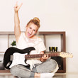 Mädchen im Wohnzimmer mit Gitarre