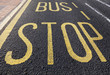 Bus stop sign painted on asphalt road