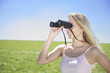 Photo: young woman looking through binocular young woman looking through binocular
