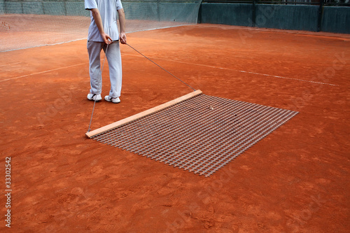 Photo: man cleaning tennis court man cleaning tennis court