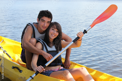 Photo: young man and woman doing canoe on a lake young man and woman doing canoe on a lake