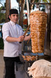 Foto: Chef slicing Turkish doner kebab. Chef slicing Turkish doner kebab.