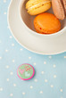 French macaroons into a cup causer on blue background
