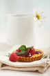 raspberry tart on a napkin, in background white flower