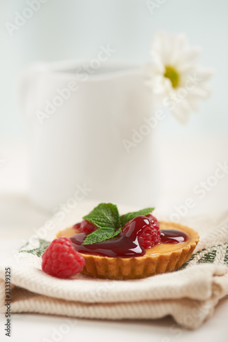 Photo: raspberry tart on a napkin, in background white flower raspberry tart on a napkin, in background white flower