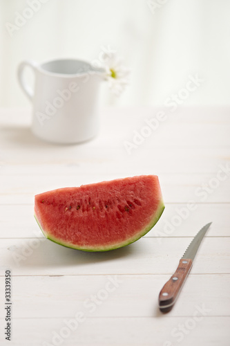Photo: watermelon on a white wood table in the kitchen watermelon on a white wood table in the kitchen