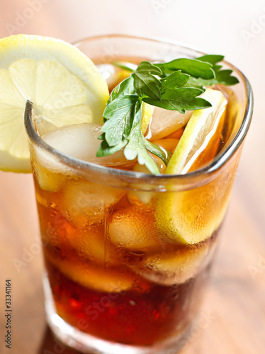 Photo: iced tea with lemon slice and leaf garnish. iced tea with lemon slice and leaf garnish.