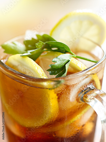 Photo: iced tea with lemon slice and leaf garnish. iced tea with lemon slice and leaf garnish.