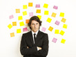 young businessman with postit reminder notes on the background young businessman with postit reminder notes on the background