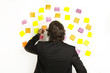 young businessman with postit reminder notes on the background young businessman with postit reminder notes on the background