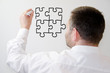 Mann zeichnet ein Puzzle