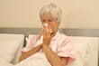 Seniorin im Bett mit Erkältung