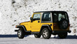 A Yellow SUV on a rural snowy  road,