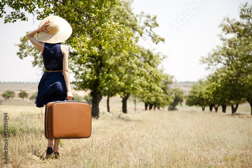 Photo: Lonely girl with suitcase at countryside. Lonely girl with suitcase at countryside.