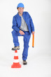 Builder with foot on traffic cone.