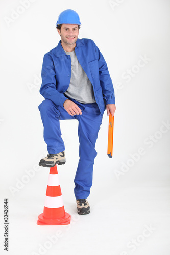 Photo: Builder with foot on traffic cone. Builder with foot on traffic cone.