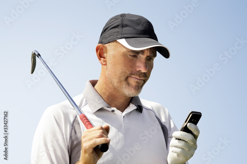 Photo: Golfer using mobile phone Golfer using mobile phone