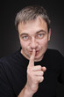 Foto: Shh. secret - Young man with his finger over his mouth Shh. secret - Young man with his finger over his mouth