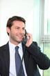 Smiling man using an office phone