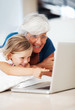 Girl using laptop with grandmother