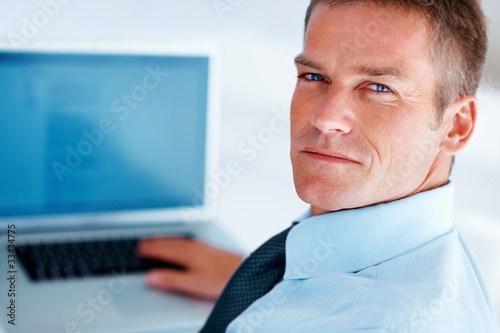 Photo: Confident man using laptop Confident man using laptop
