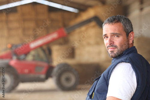 Foto: farmer posing in front of a tractor farmer posing in front of a tractor