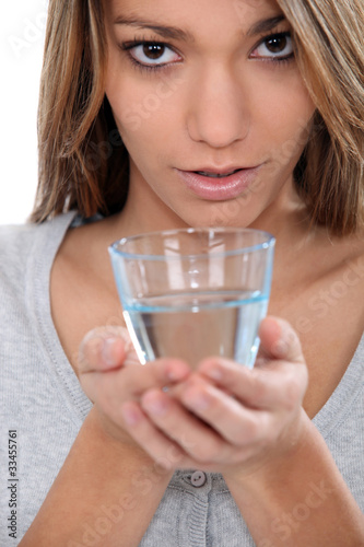 Photo: Woman holding a glass of water Woman holding a glass of water