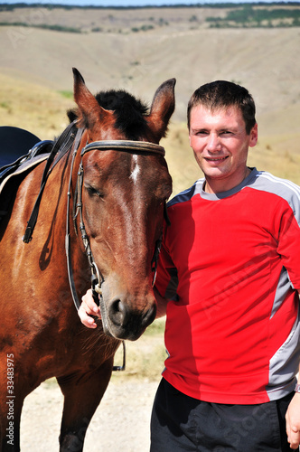 Photo: smiling man petting his horse smiling man petting his horse